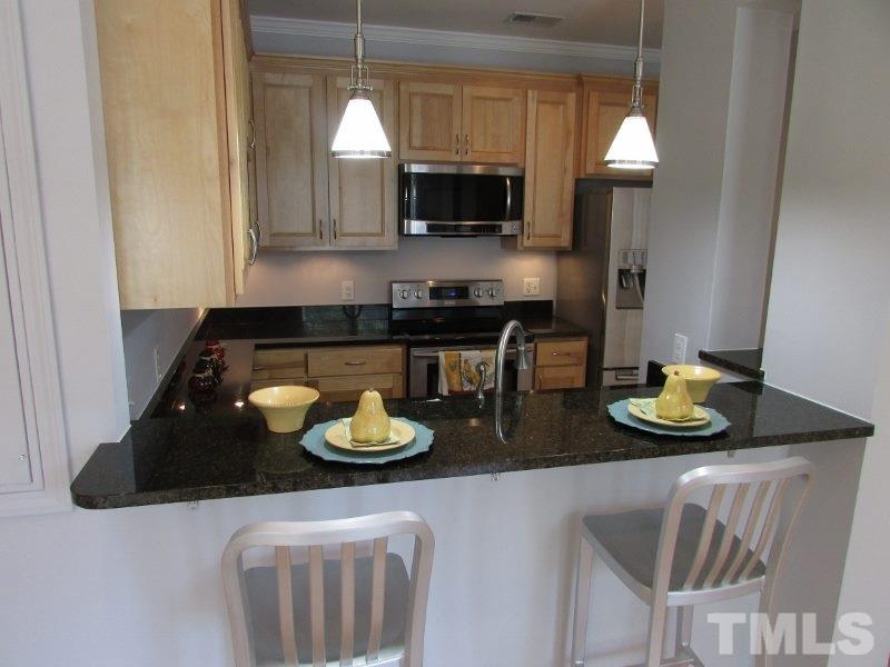 720 North Person Street, Unit 103 Raleigh, NC 27604 - Photo 7 of 13 a kitchen with furniture and a wooden floor
