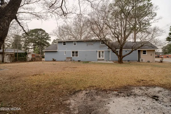 a front view of house with yard and trees around