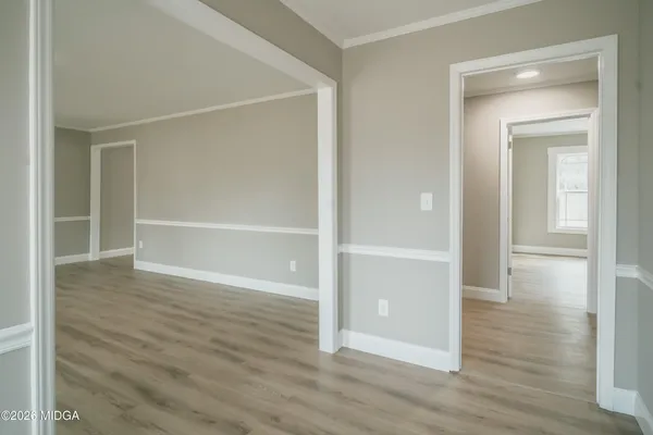 a view of an empty room with wooden floor & closet