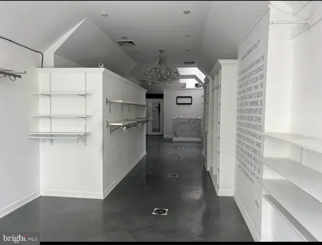 a view of a refrigerator in kitchen and an empty room