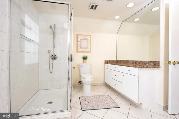 a bathroom with a granite countertop sink a toilet and shower