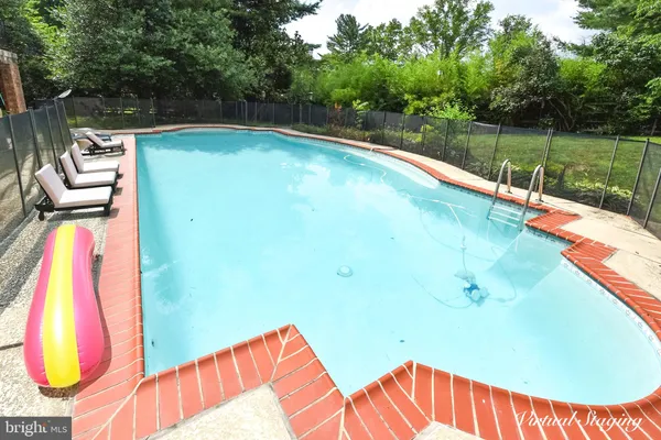 a view of a swimming pool with a backyard and trees