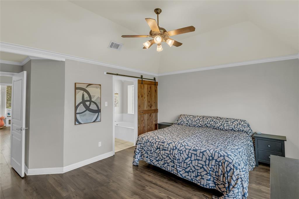 5613 Landsdown Drive Waco, TX 76708 - Photo 15 of 27 a bedroom with a large bed and a chandelier