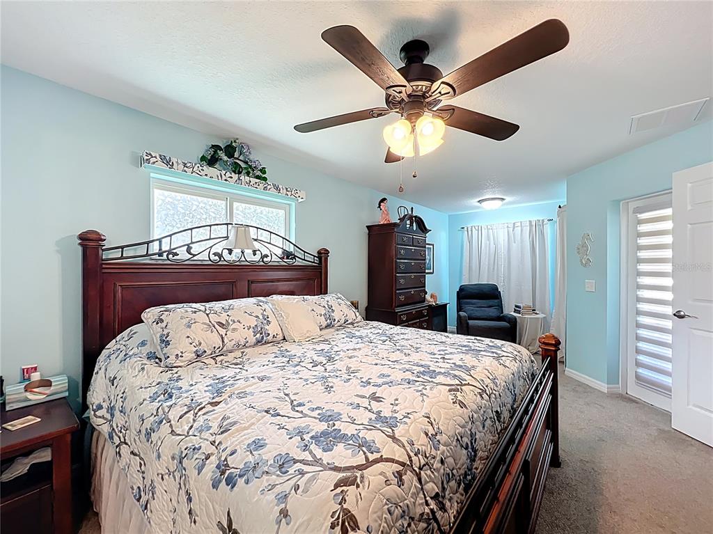 4501 East Ravenna Street Inverness, FL 34453 - Photo 12 of 31 a bed sitting in a bedroom and a chandelier