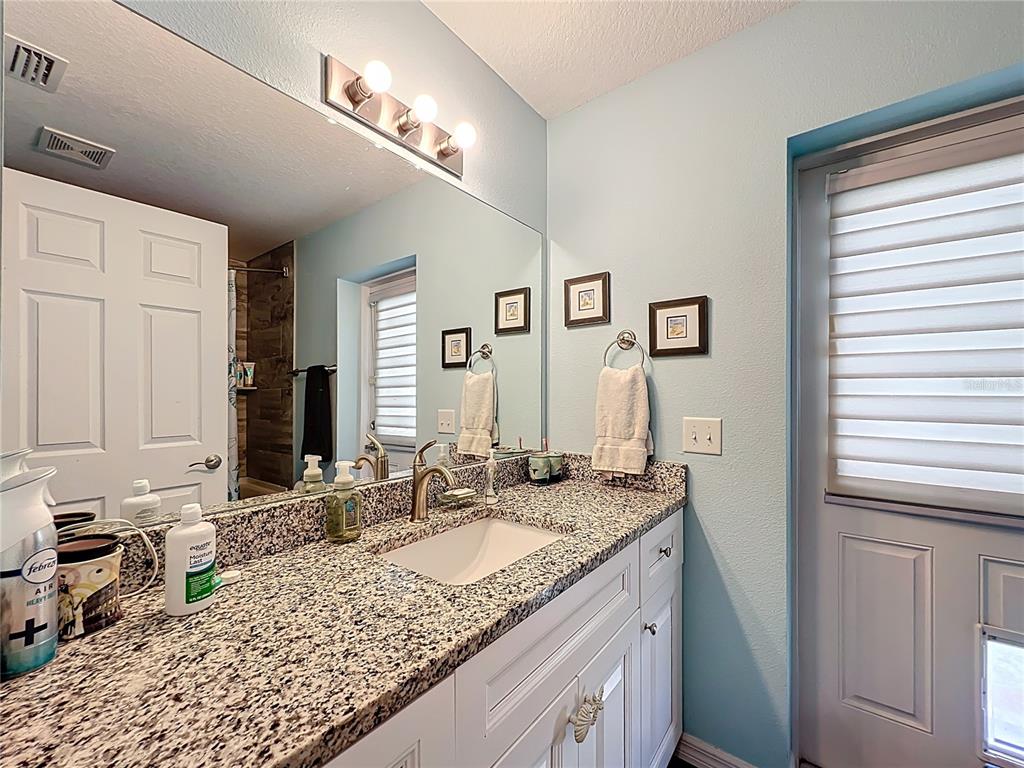 4501 East Ravenna Street Inverness, FL 34453 - Photo 21 of 31 a bathroom with a granite countertop sink and a mirror