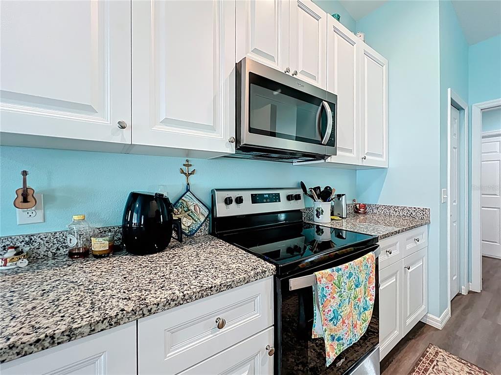 4501 East Ravenna Street Inverness, FL 34453 - Photo 8 of 31 a kitchen with stainless steel appliances granite countertop white cabinets sink and stove