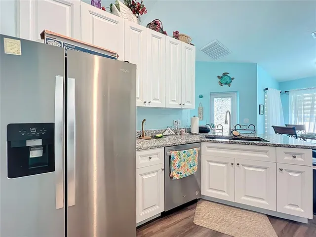 a kitchen with stainless steel appliances white cabinets and a refrigerator