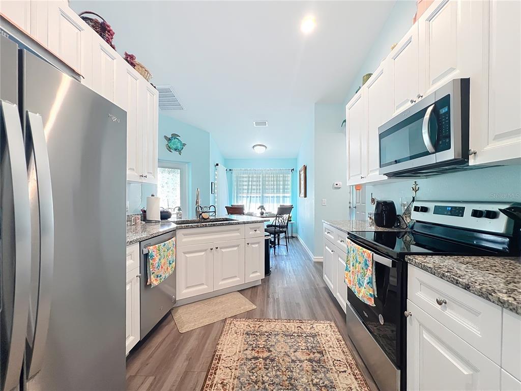 4501 East Ravenna Street Inverness, FL 34453 - Photo 10 of 31 a kitchen with stainless steel appliances granite countertop a refrigerator a stove top oven a sink and dishwasher