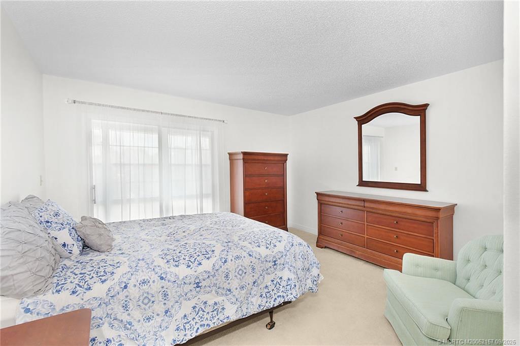 2600 Southeast Ocean Boulevard, Unit H15 Stuart, FL 34996 - Photo 13 of 27 a bedroom with a bed and a dresser with mirror