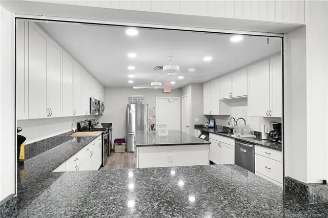 a large white kitchen with lots of counter space a sink and appliances