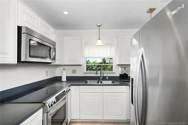 a kitchen with granite countertop a refrigerator and a sink
