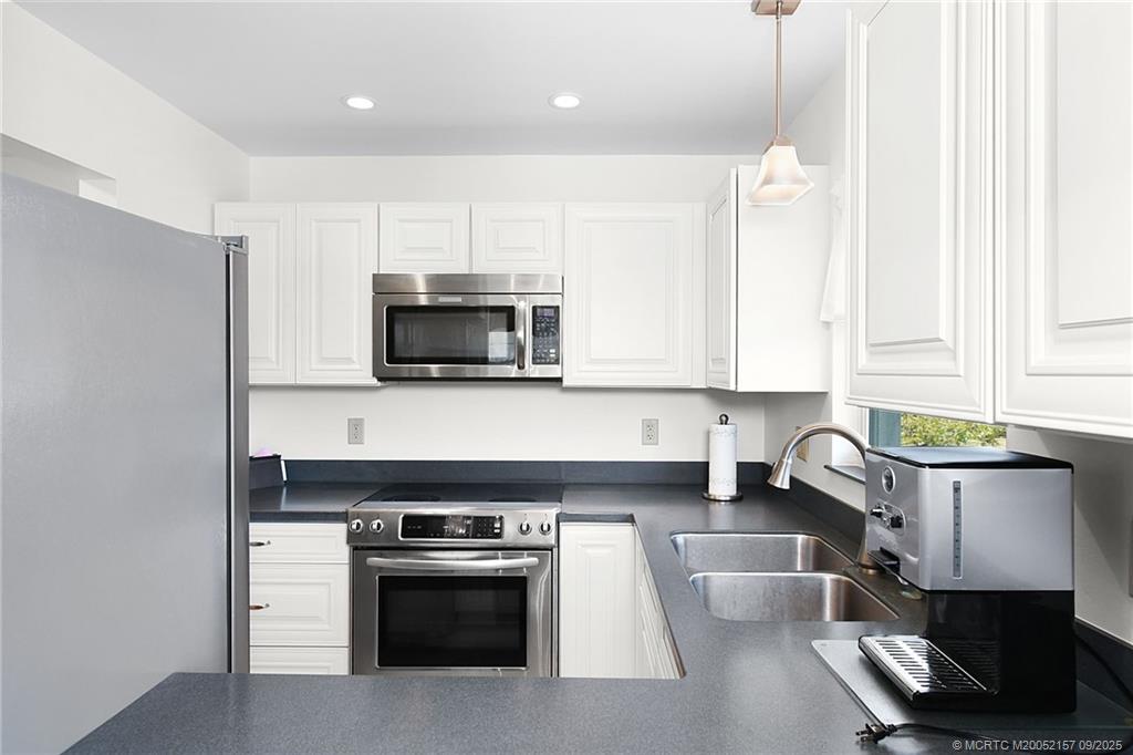 2600 Southeast Ocean Boulevard, Unit H15 Stuart, FL 34996 - Photo 7 of 27 a kitchen with stainless steel appliances a stove a microwave a sink and white cabinets