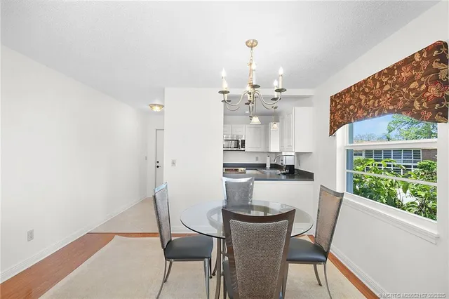 a view of a dining room with furniture a rug and wooden floor