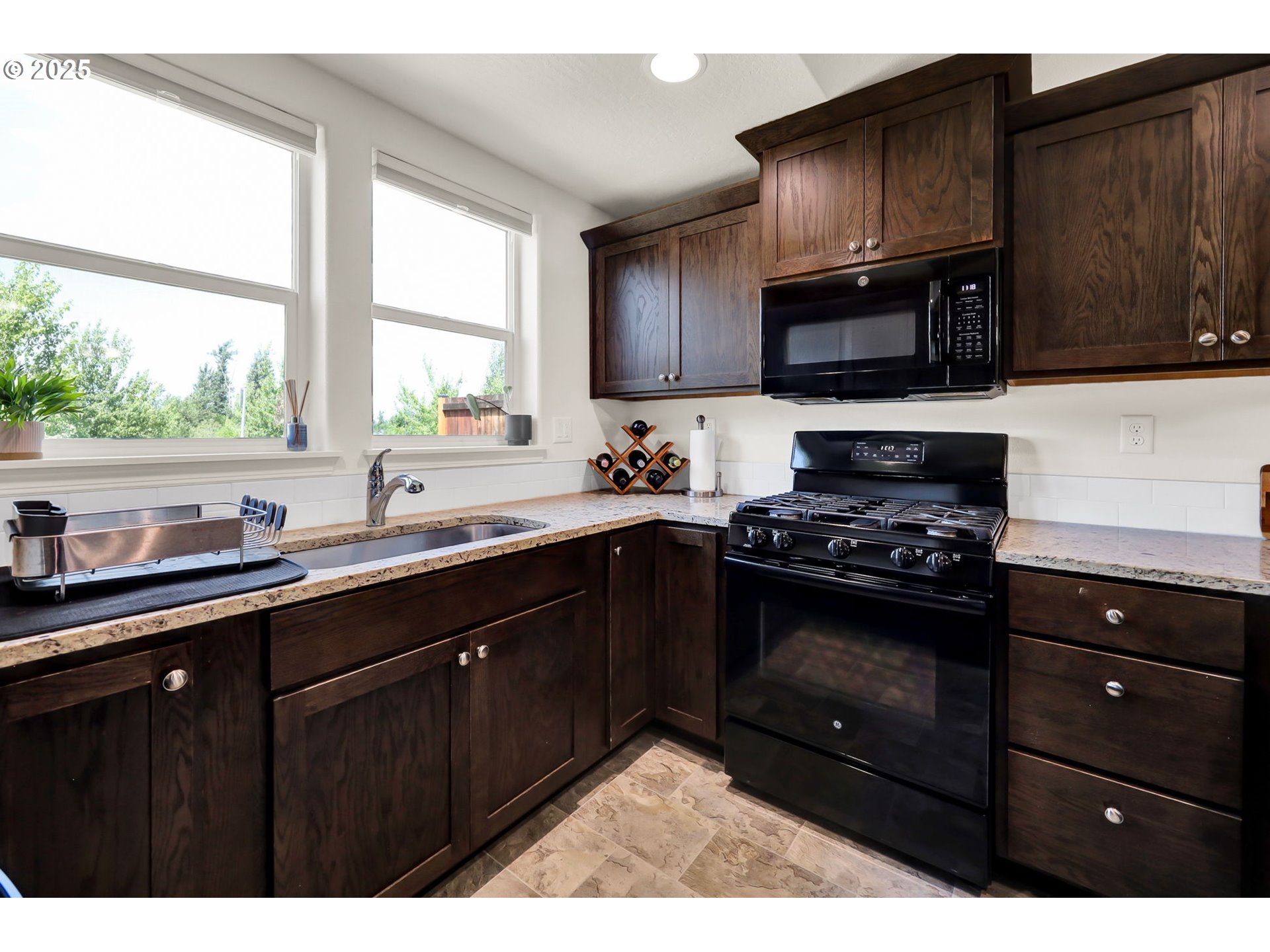 2057 South 59th Street Springfield, OR 97478 - Photo 13 of 28 a kitchen with stainless steel appliances granite countertop a sink a stove a microwave and wooden cabinets