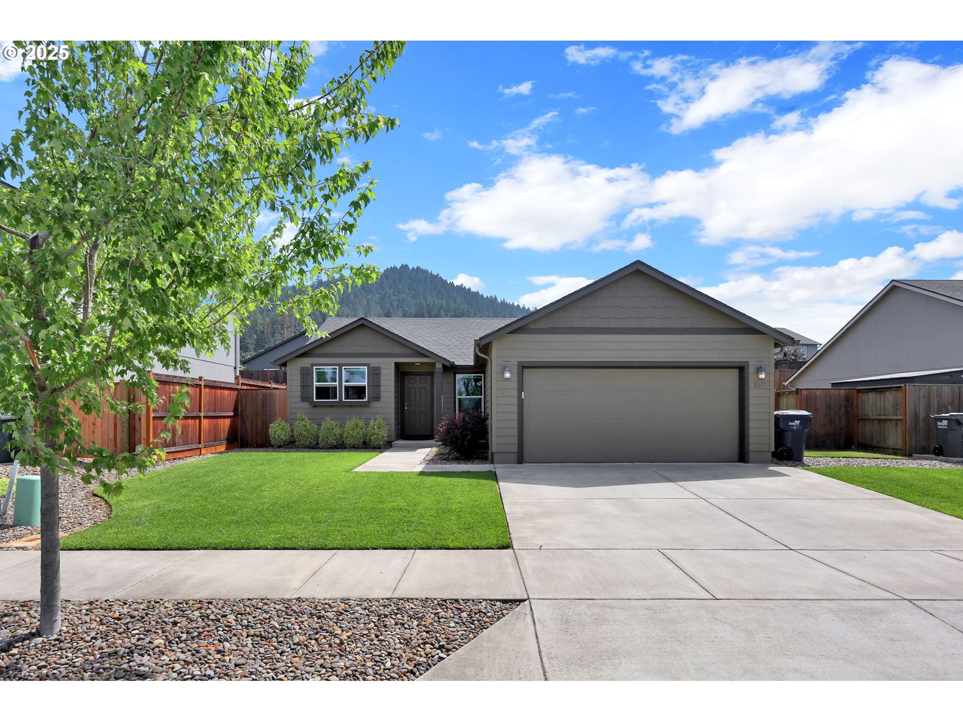 2057 South 59th Street Springfield, OR 97478 - Photo 2 of 28 a house with a yard and a large tree