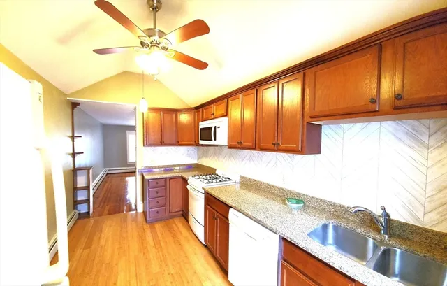 a kitchen with stainless steel appliances granite countertop a sink a stove cabinets counter space and a window