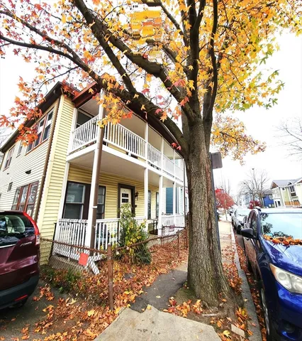 a front view of a house with a tree