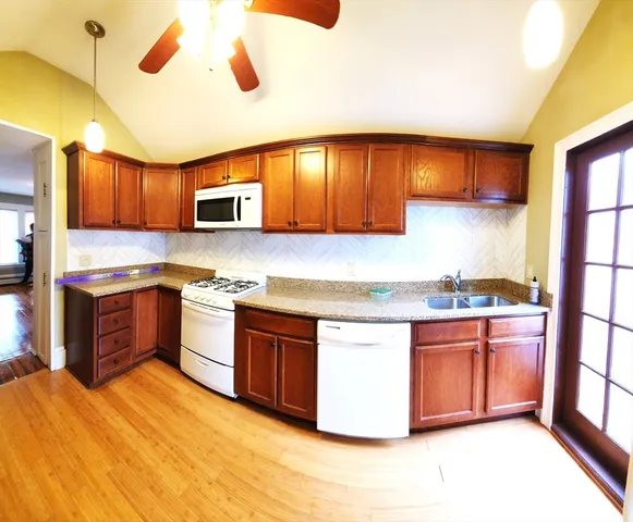 a kitchen with stainless steel appliances kitchen island granite countertop a stove a sink and a refrigerator