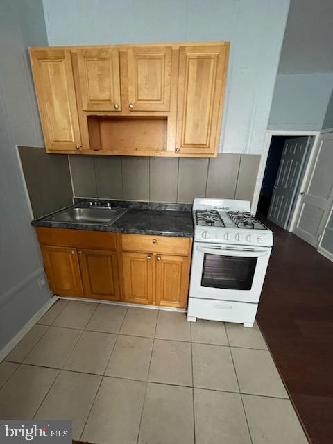 3412 North Front Street Philadelphia, PA 19140 - Photo 8 of 10 a kitchen with granite countertop a stove a sink and a microwave