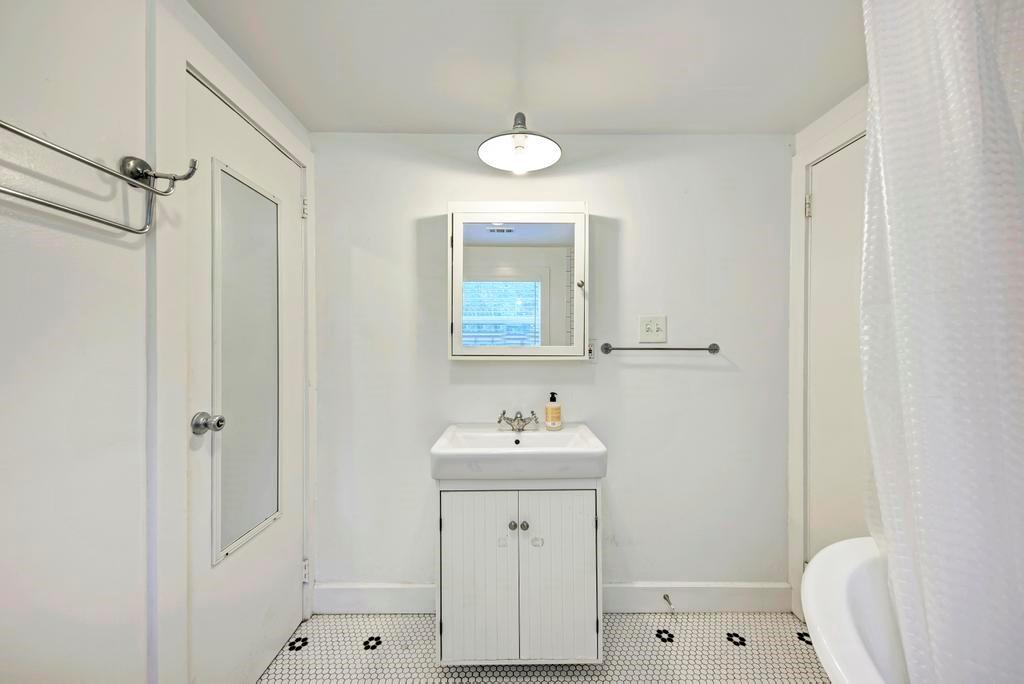 1407 Leona Street, Unit A Austin, TX 78702 - Photo 19 of 25 Bathroom with a shower with shower curtain, vanity, and tile patterned flooring