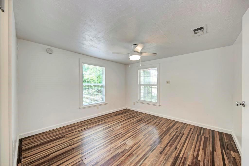 1407 Leona Street, Unit A Austin, TX 78702 - Photo 20 of 25 Unfurnished room with wood finished floors, a textured ceiling, and a ceiling fan