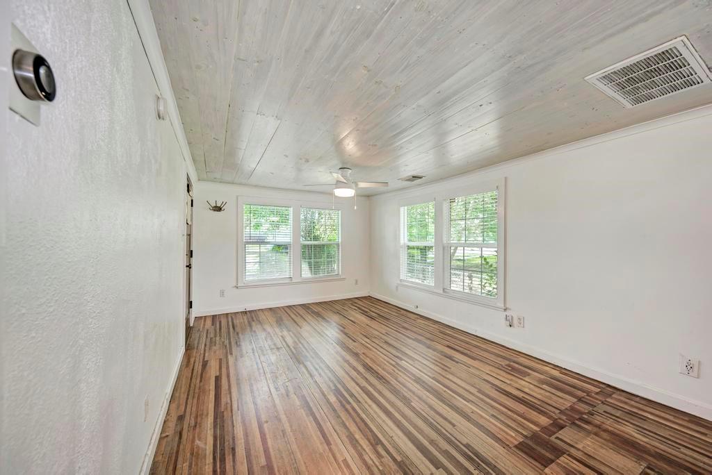 1407 Leona Street, Unit A Austin, TX 78702 - Photo 7 of 25 Empty room featuring hardwood / wood-style flooring, wood ceiling, ceiling fan, and crown molding