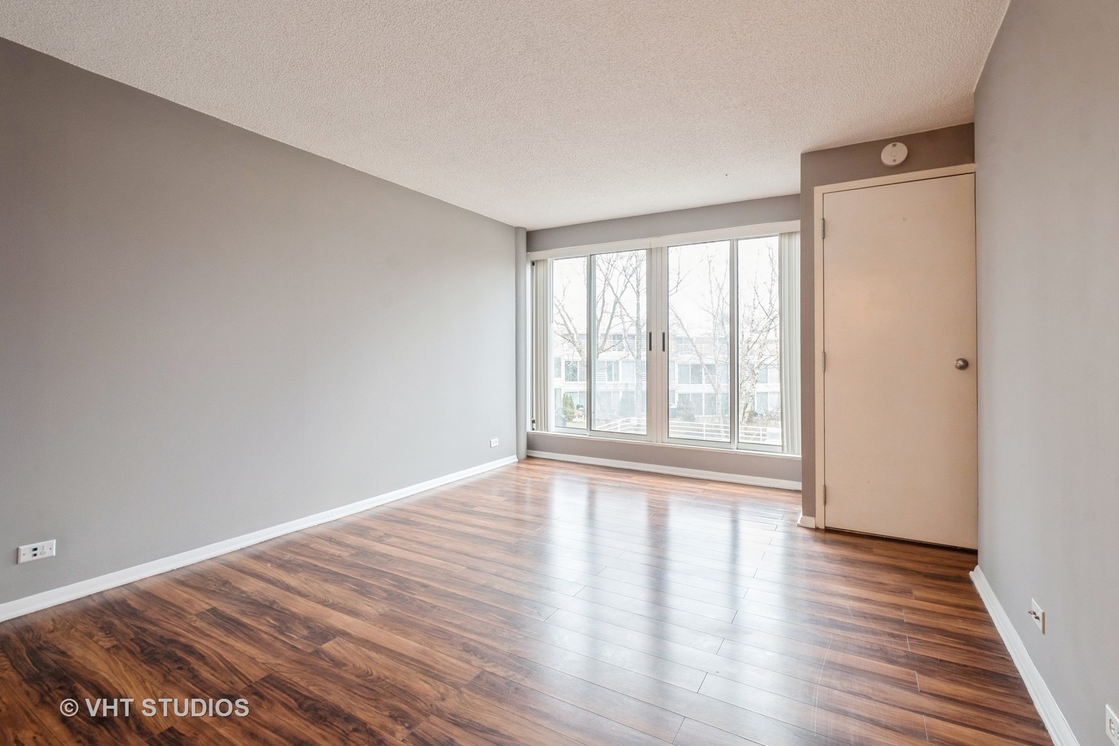 2555 Gross Point Road, Unit 201 Evanston, IL 60201 - Photo 8 of 15 a view of an empty room with wooden floor and a window