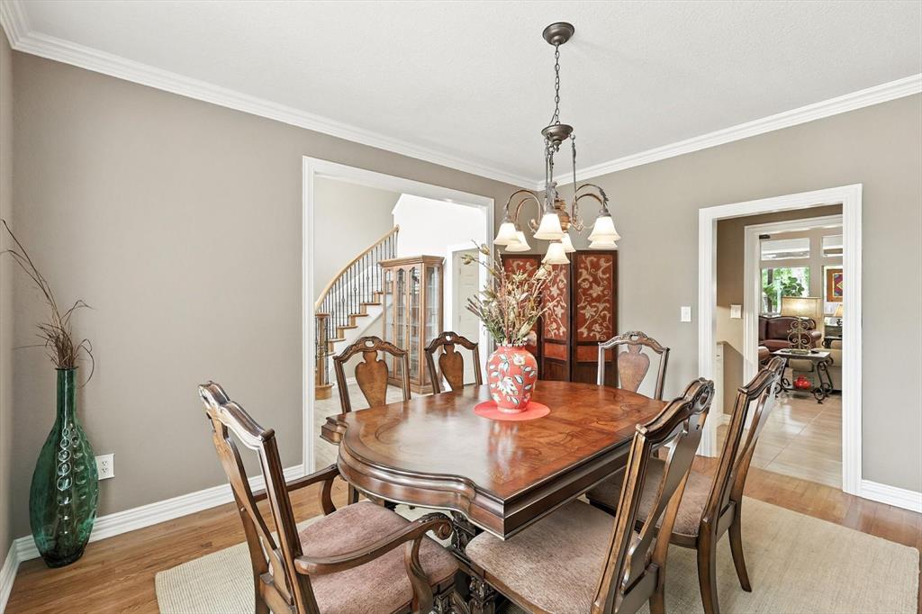 109 Visalia Lane Denton, TX 76210 - Photo 11 of 36 a dining room with furniture a chandelier and wooden floor