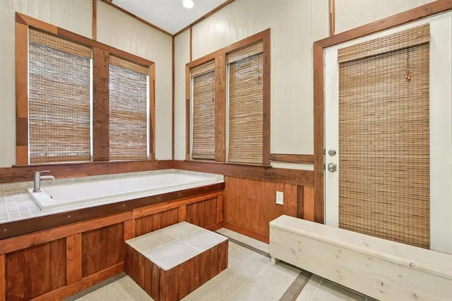 a bathroom with a tub sink and mirror