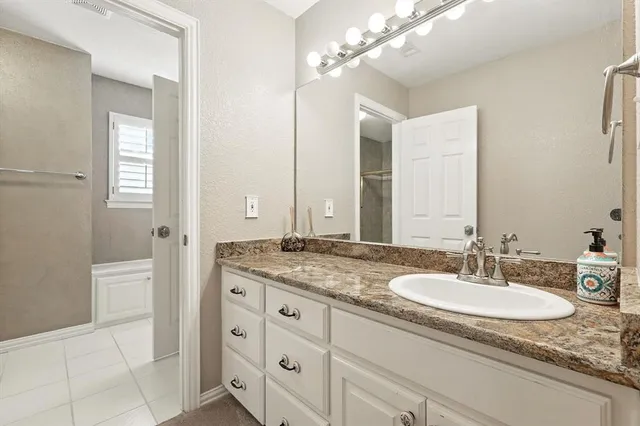 a bathroom with a granite countertop sink and a mirror