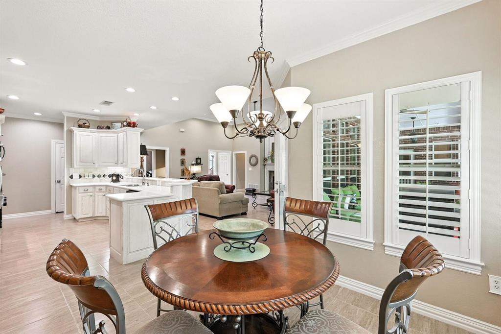 109 Visalia Lane Denton, TX 76210 - Photo 6 of 36 a dining room with wooden floor a chandelier a glass table and chairs