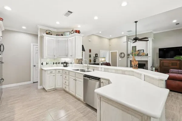 a large white kitchen with cabinets a sink and a stove