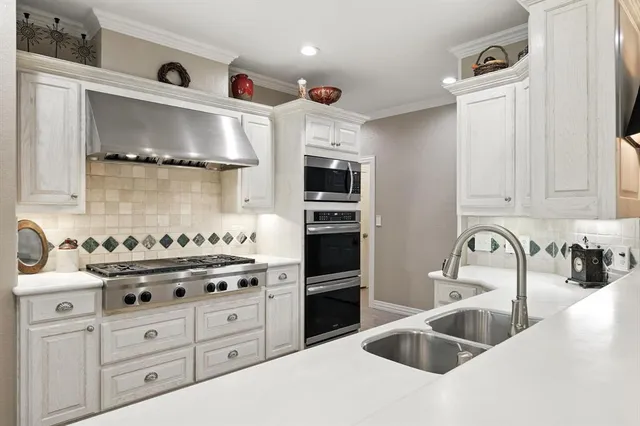 a kitchen with granite countertop a sink stainless steel appliances and cabinets