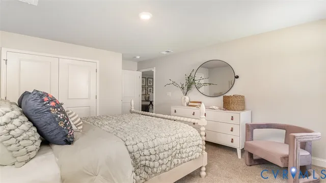 a bed room with a bed a mirror and a dresser