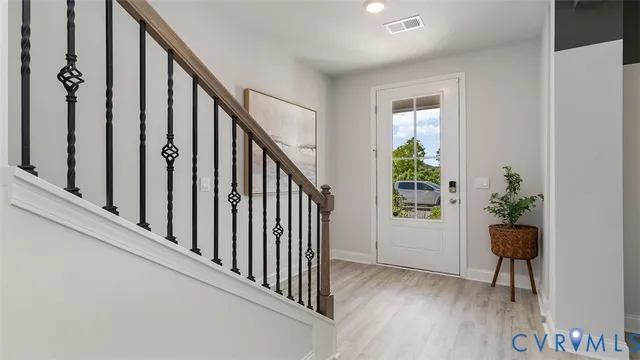 a view of a hallway with wooden floor and stairs
