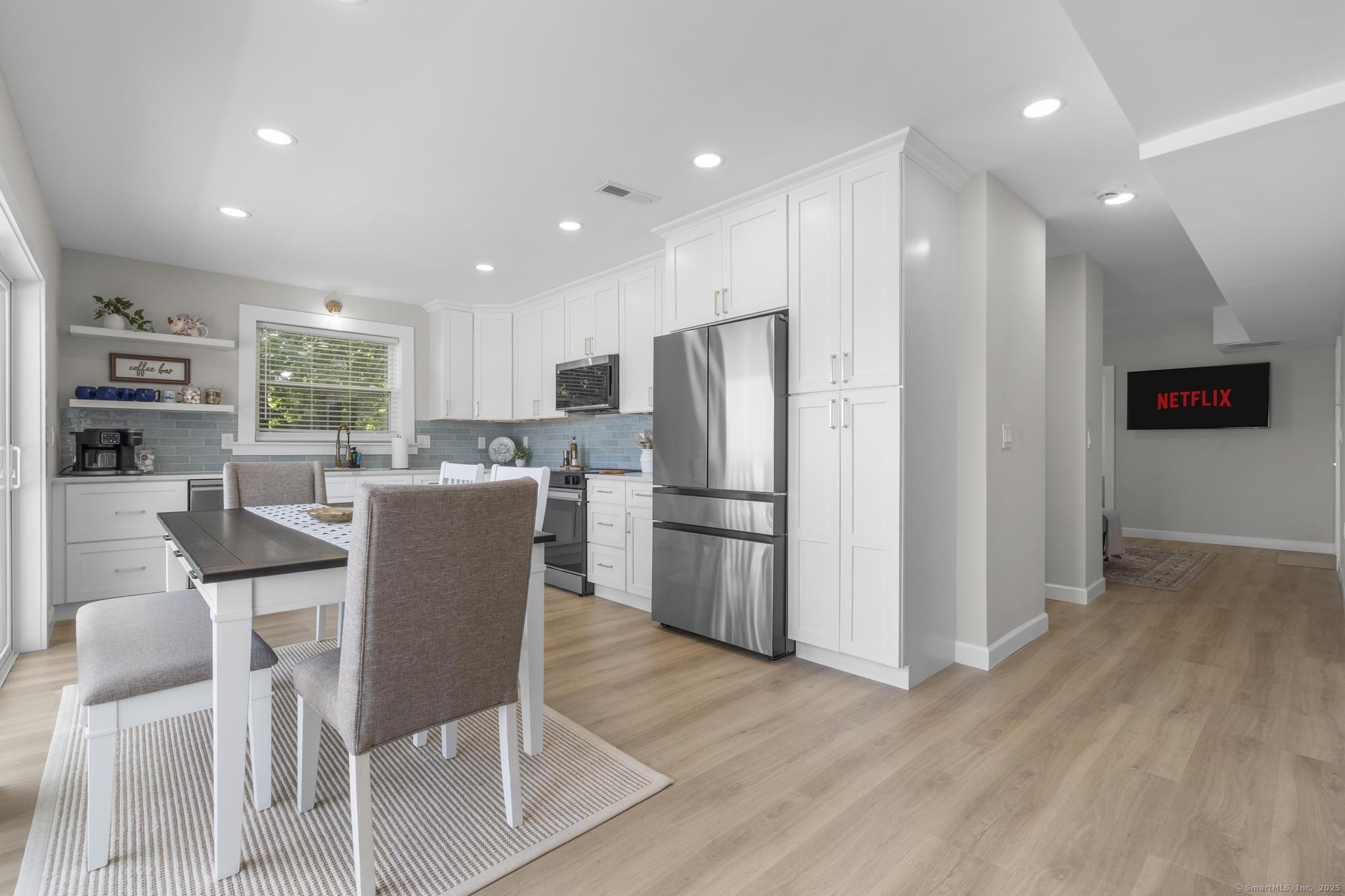 270 Elm Street, Unit 2 Groton, CT 06340 - Photo 15 of 36 a kitchen with stainless steel appliances granite countertop a refrigerator a stove a sink dishwasher and a dining table with wooden floor