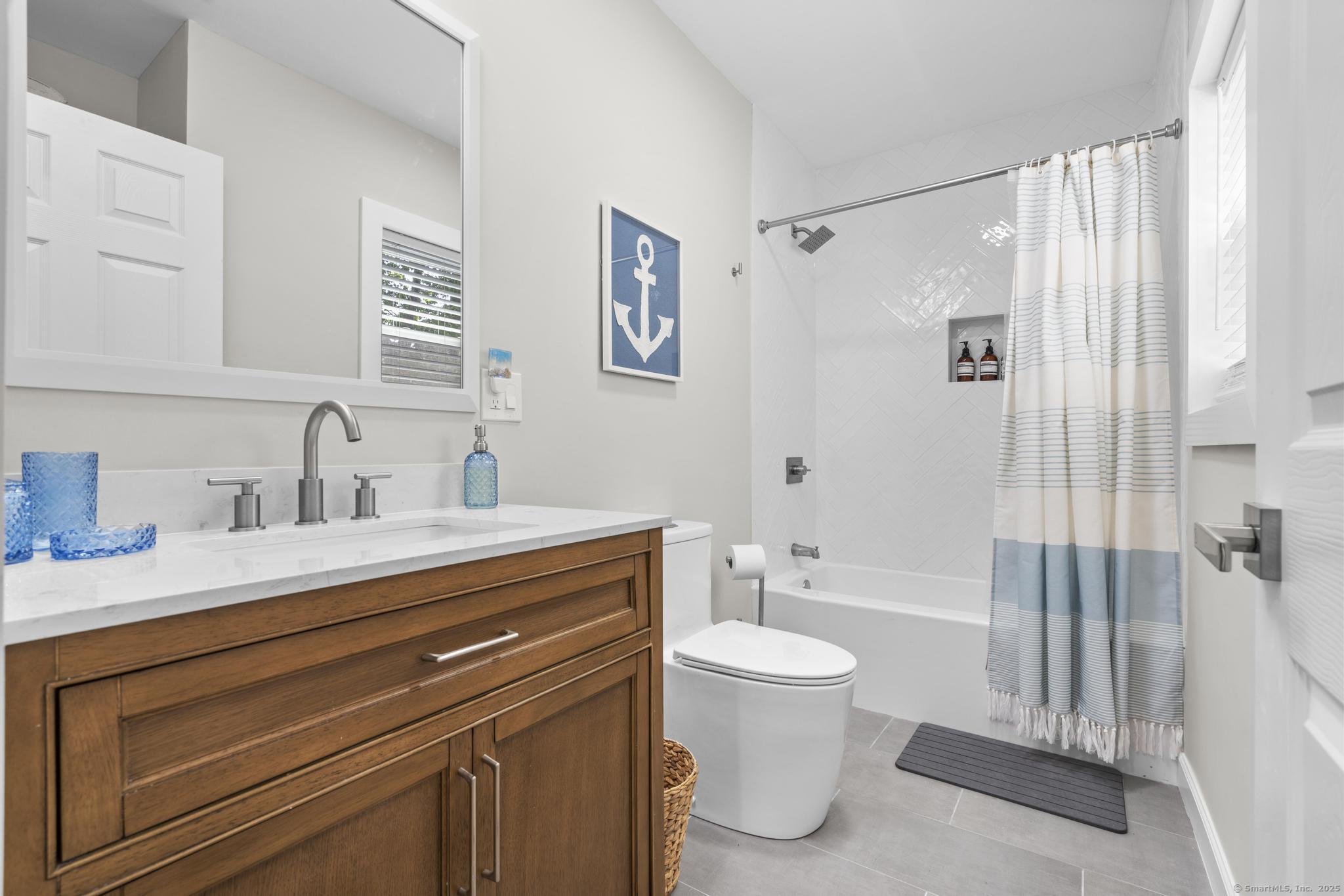 270 Elm Street, Unit 2 Groton, CT 06340 - Photo 24 of 36 a bathroom with a sink a toilet and a large mirror