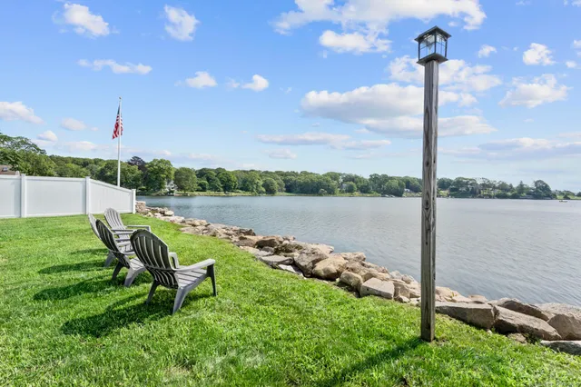 a view of a lake with couches in the back yard