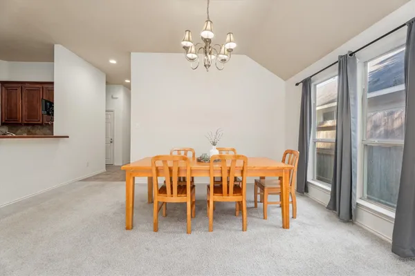 a dining room with chandelier fan and a chandelier