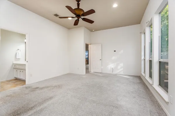 an empty room with fan and windows