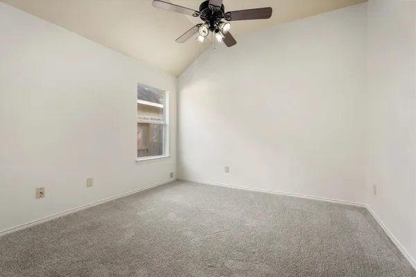 an empty room with a ceiling fan and window