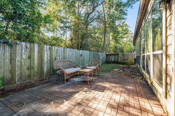 a view of a patio with table and chairs with wooden fence and plants