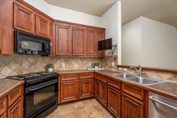 a kitchen with stainless steel appliances granite countertop a refrigerator stove and sink