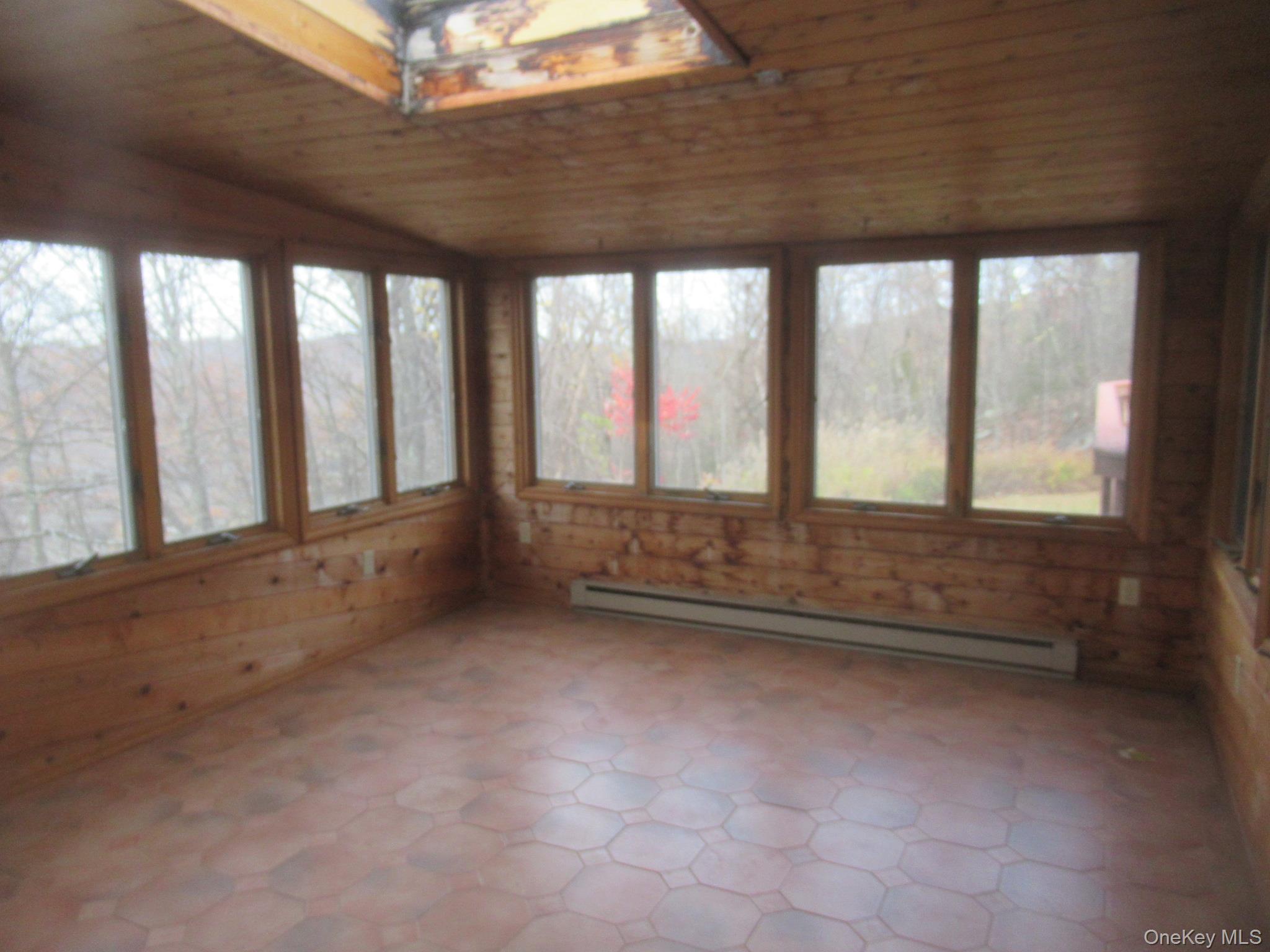 64 Hillside View Road Mahopac, NY 10541 - Photo 17 of 25 Unfurnished sunroom with wood ceiling, a baseboard heating unit, vaulted ceiling, wooden walls, and tile patterned floors