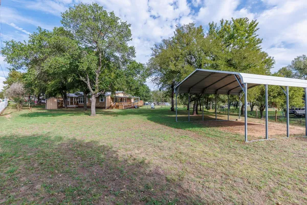 a backyard of a house with table and chairs under an umbrella