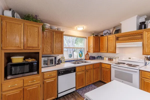 a kitchen with stainless steel appliances granite countertop a sink stove and cabinets