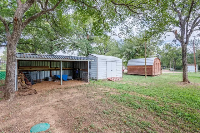 a backyard of a house with barbeque oven table and chairs