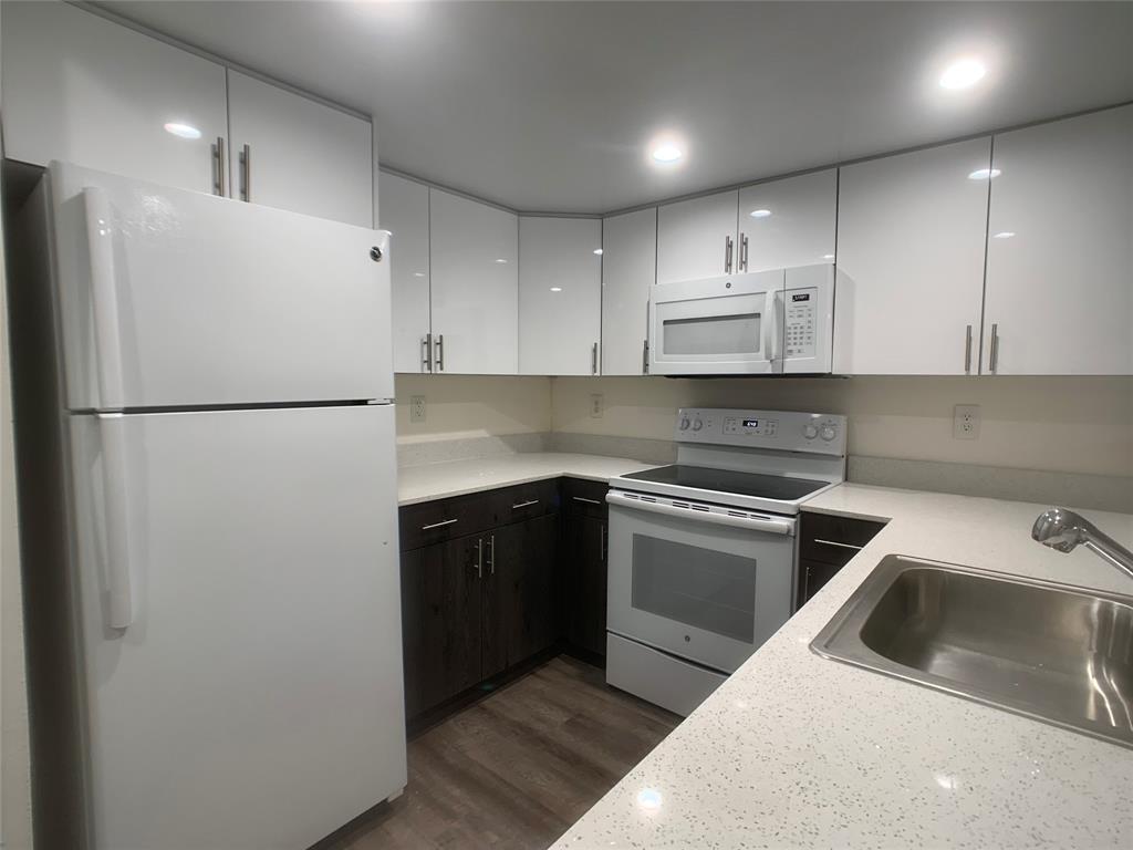 a kitchen with a refrigerator sink and cabinets