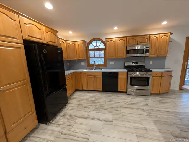 a view of kitchen with stainless steel appliances granite countertop a refrigerator and a sink