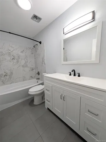 a bathroom with a double vanity sink toilet mirror and bathtub